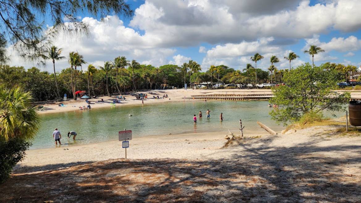 Wide sandy beach at Jupiter Beach Park with the inlet in the background